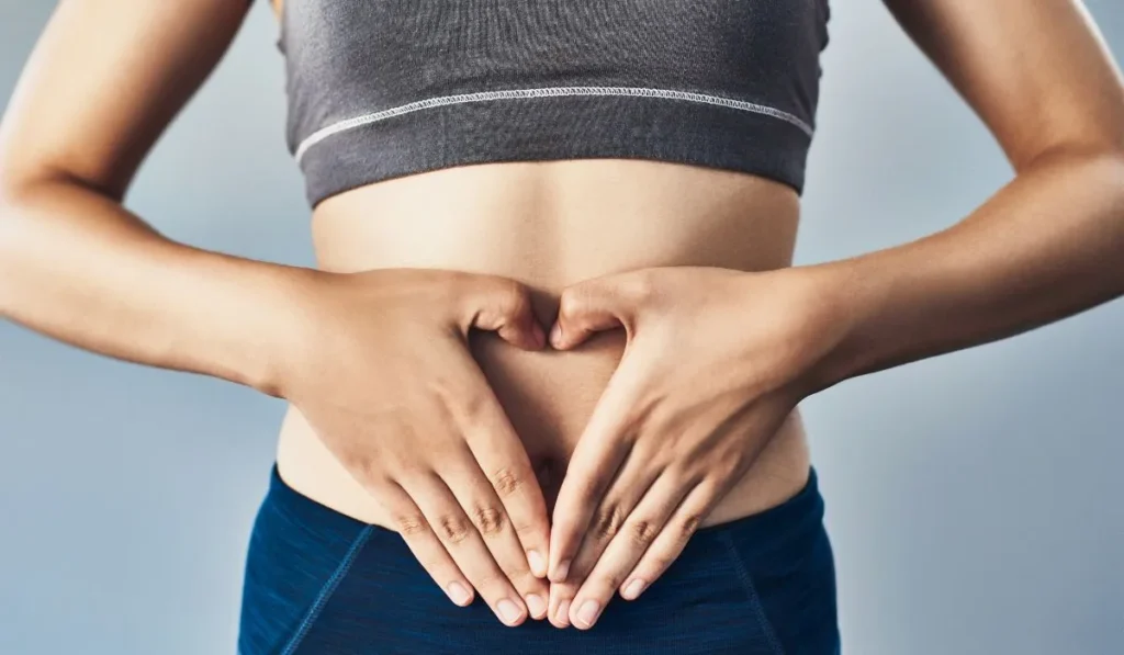 woman pressing hands against stomach - Lynk Diagnostics woman pressing hands against stomach