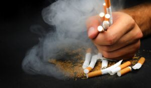 person grabbing and crushing cigarettes