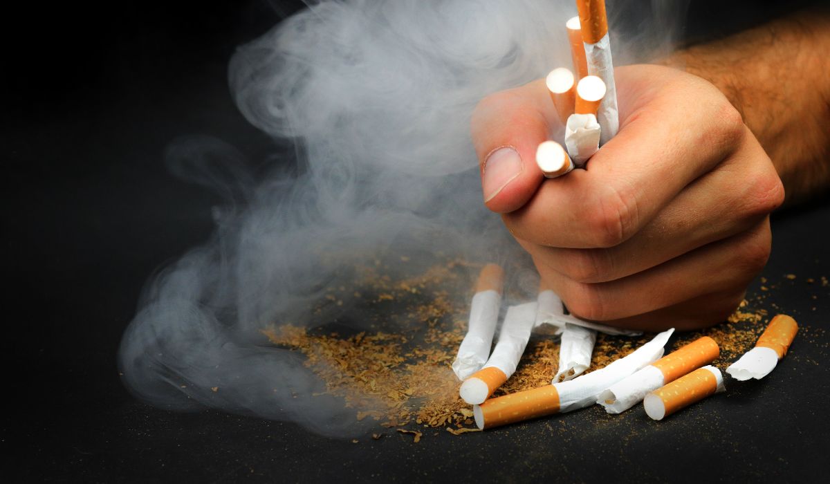 person grabbing and crushing cigarettes
